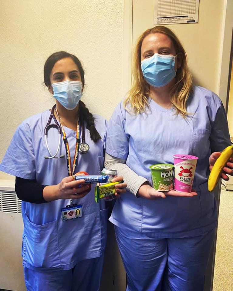 Two masked nurses with snack nags